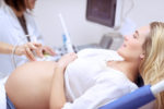 doctor performing ultrasound on pregnant patient.